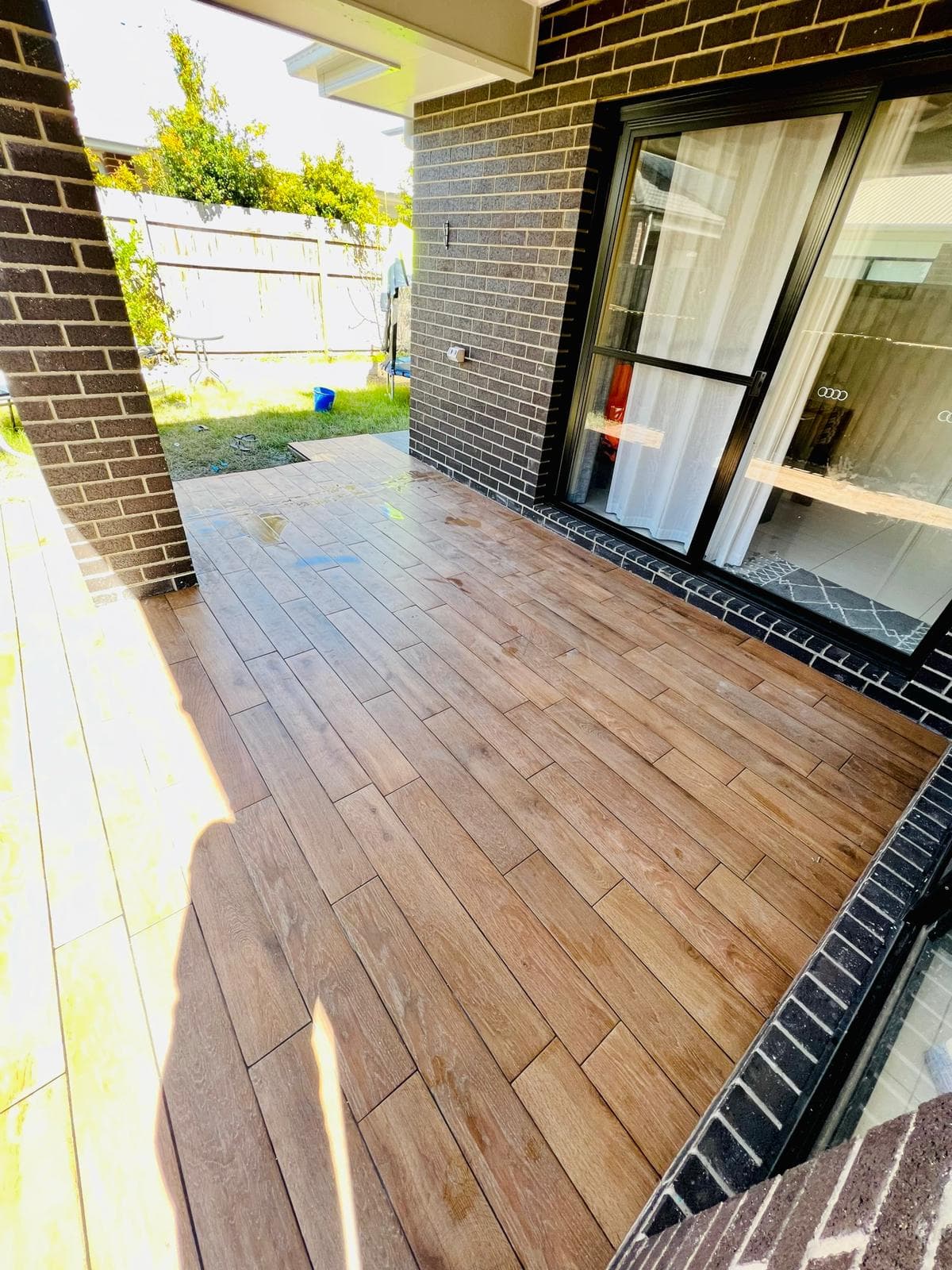 Covered outdoor tiled area with table and chairs